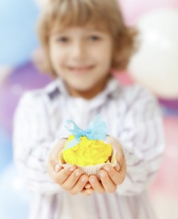 Close up of boy holding decorated cupcake