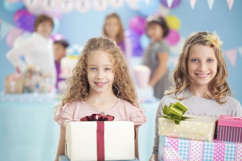 Girls holding wrapped gifts at birthday party