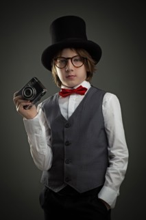 Boy in top hat photographing with vintage camera
