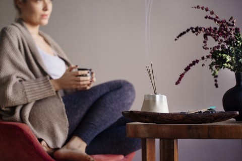 Caucasian woman burning incense in living room