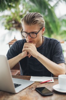 Caucasian man using laptop in cafe