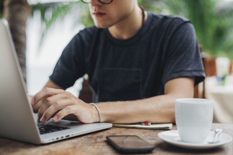 Caucasian man using laptop in cafe