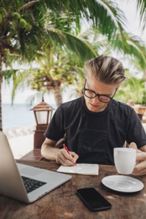Caucasian man writing in cafe