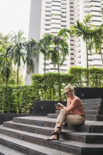 Caucasian woman using cell phone on stairs