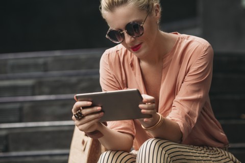 Caucasian woman using digital tablet on stairs