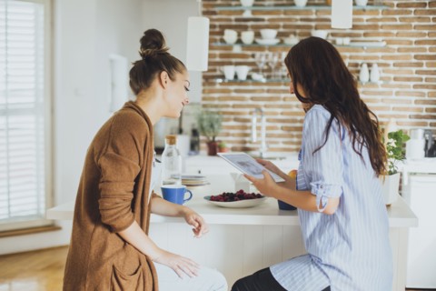 Caucasian women using digital tablet at counter