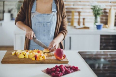 Caucasian woman chopping fruit in kitchen