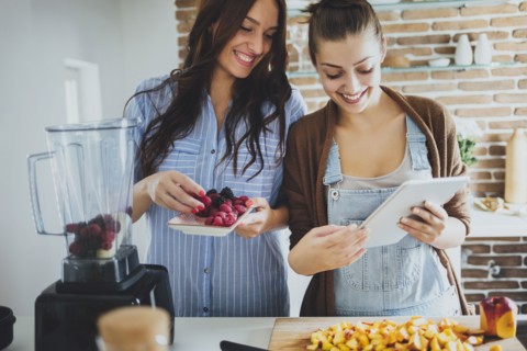 Caucasian women using digital tablet in kitchen