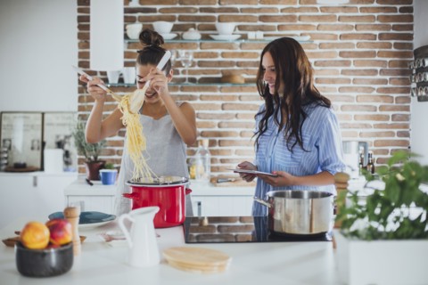 Caucasian women cooking pasta in kitchen