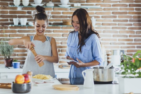 Caucasian women cooking pasta in kitchen