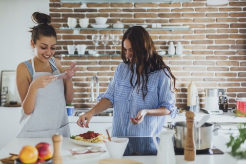 Caucasian women cooking pasta in kitchen