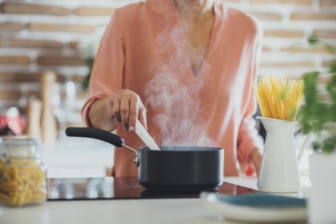Older Caucasian woman cooking in kitchen