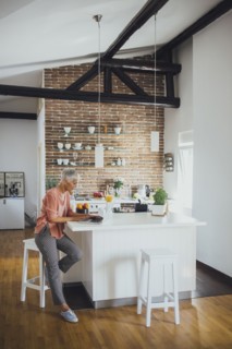 Older Caucasian woman using laptop in kitchen