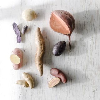 Variety of potatoes on white wooden table