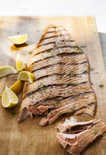 Salmon on cutting board with lemon wedges