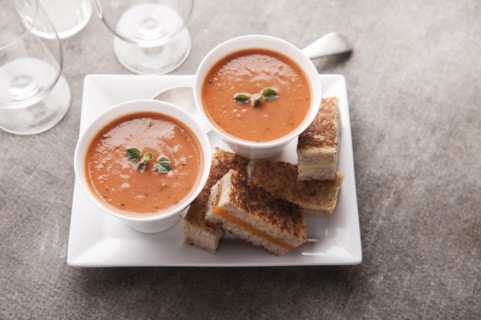 Sliced grilled cheese sandwich and tomato soup