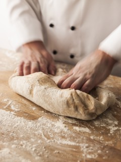 Hands of baker kneading dough