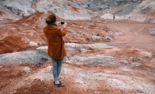 Caucasian woman photographing rock formations
