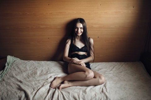 Caucasian woman sitting on bed