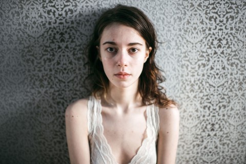 Caucasian woman standing at wallpaper