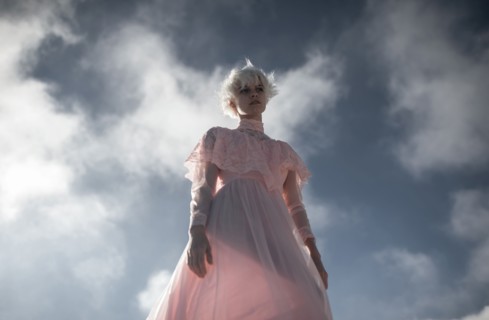 Caucasian woman walking under cloudy sky