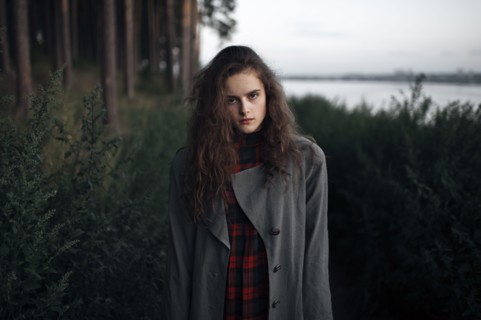 Caucasian woman standing in woods near lake