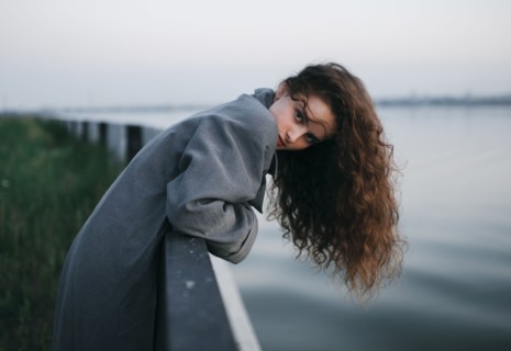 Caucasian woman leaning over river wall