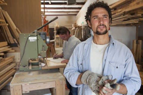 Co-workers woodworking in workshop