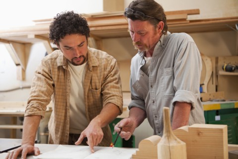 Co-workers woodworking in workshop