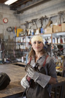 Hispanic factory worker holding metal fabricator