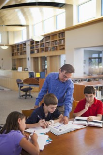 Teacher talking to students in library
