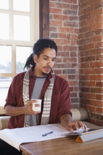 Mixed race man using digital tablet in coffee shop