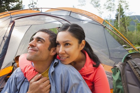 Smiling couple camping together