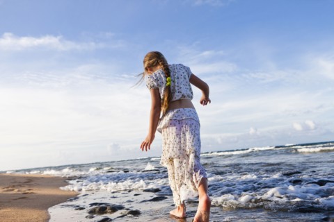 Caucasian girl walking on beach