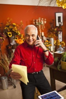 Caucasian florist talking on phone in shop