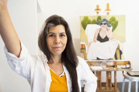 Hispanic artist smiling in studio