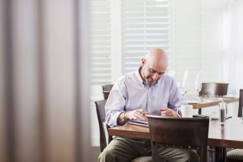Mixed race businessman working in cafe