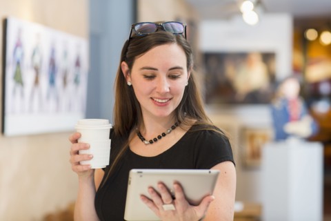 Caucasian woman using tablet computer in art gallery