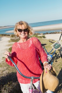 Caucasian woman riding bicycle on beach