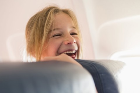 Caucasian girl laughing on airplane