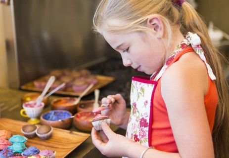 Caucasian girl making cupcakes