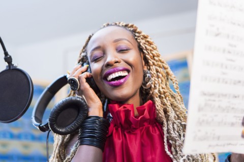 African American singer recording in studio
