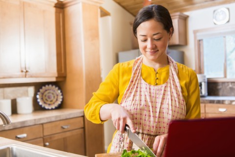 Mixed race woman cooking in kitchen