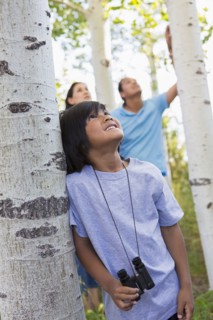 Boy with binoculars in forest