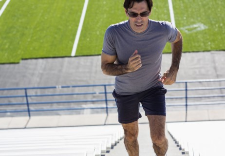 Hispanic athlete running on bleacher steps