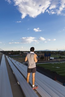 Hispanic athlete standing on bleachers