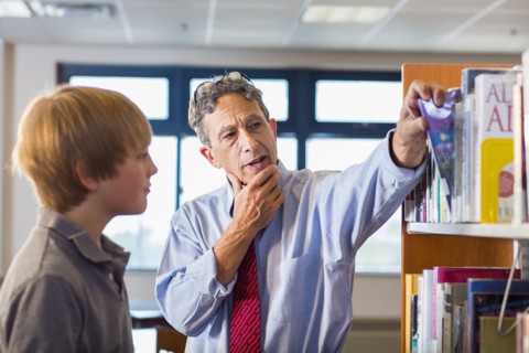 Teacher and student working in library