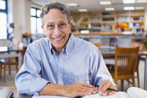 Senior man working in library