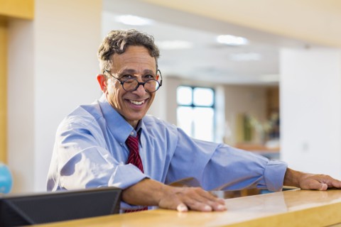 Senior man smiling in library