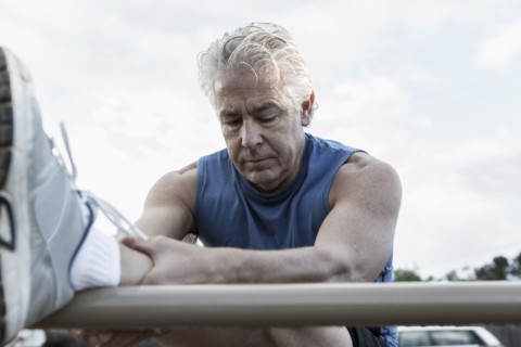 Hispanic man stretching outdoors